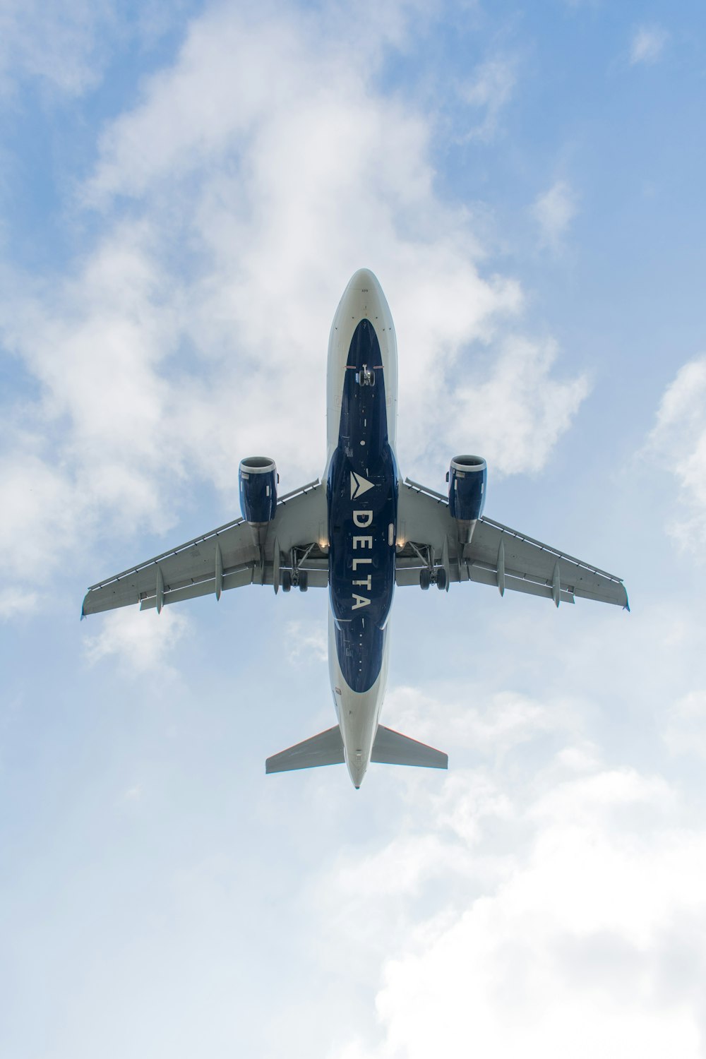 low-angle photography of white and blue Delta airliner