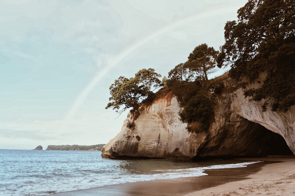 photography of mountain cliff beside seashore during daytime