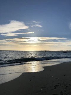 Sunset over the shimmering salt flats of Salinas beach in Ibiza, casting golden hues on the water.