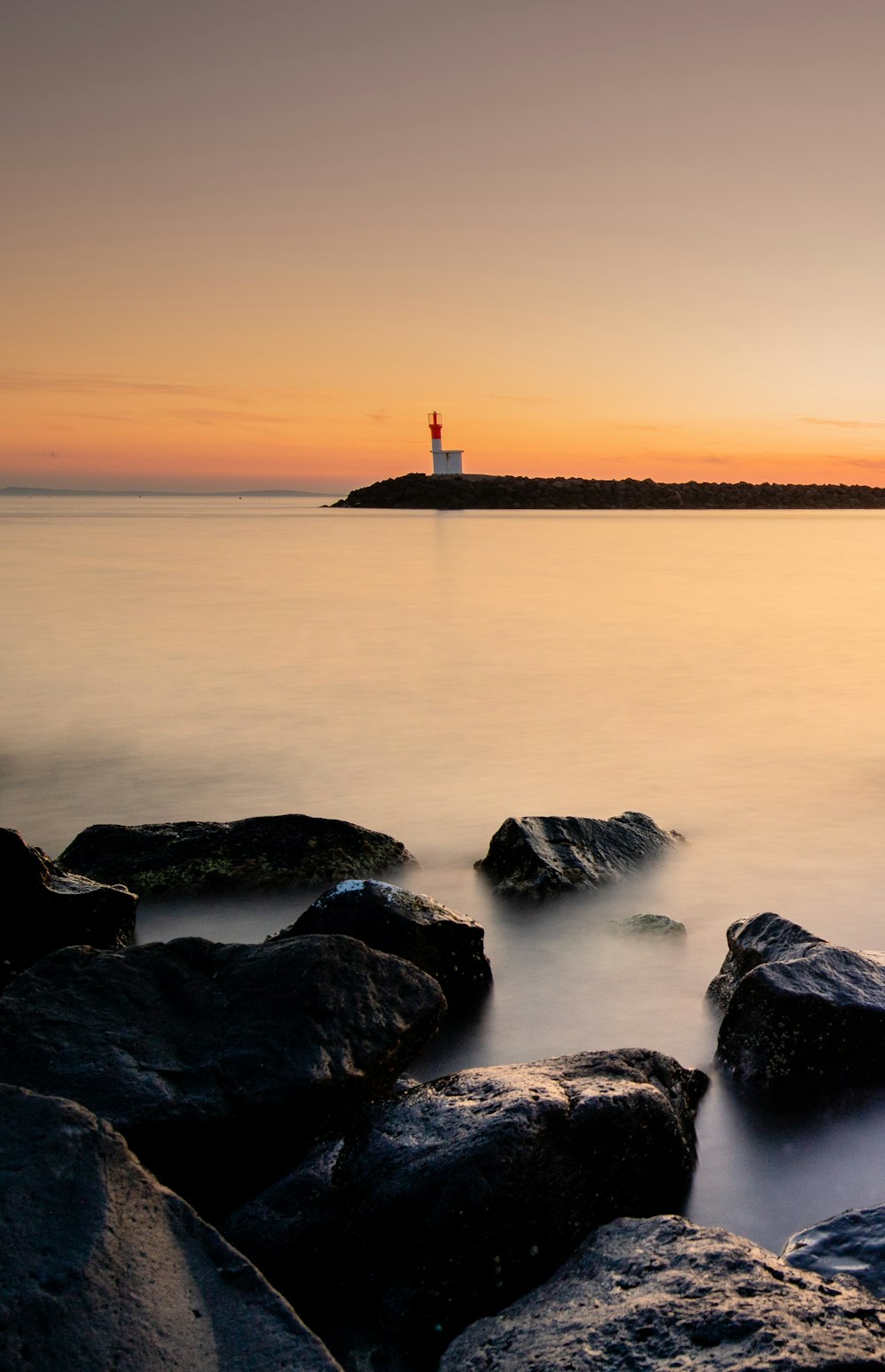 rock formation on sea at daytime