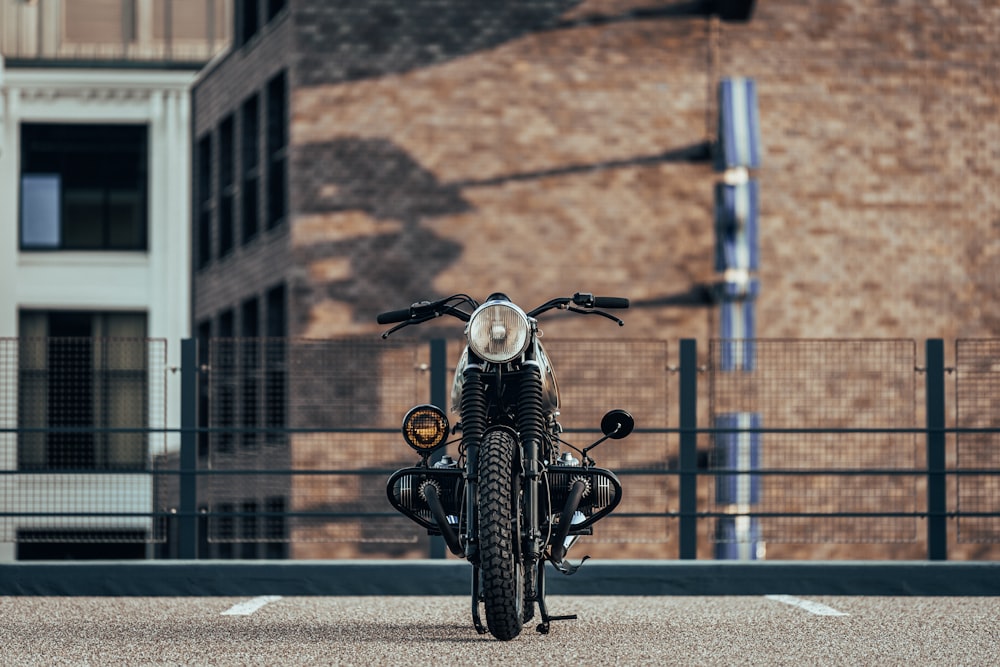 white and black cafe racer motorcycle parked near building