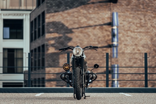 white and black cafe racer motorcycle parked near building in Eindhoven Netherlands