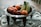 Close-up of a rustic handmade ceramic bowl filled with fresh fruit on a wooden table