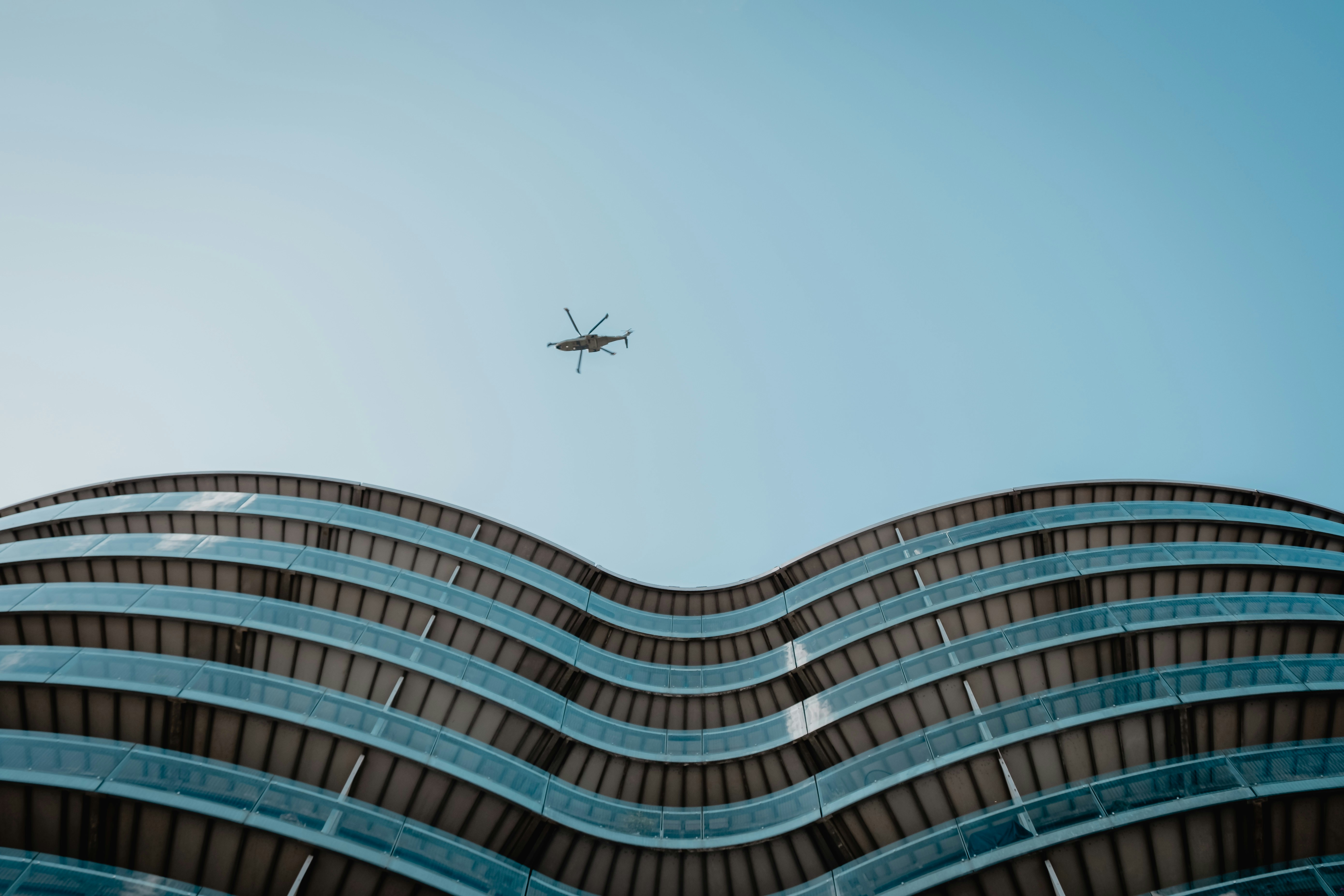 A high-angle view of a bustling city skyline with several delivery drones flying autonomously between buildings, symbolizing futuristic urban logistics.