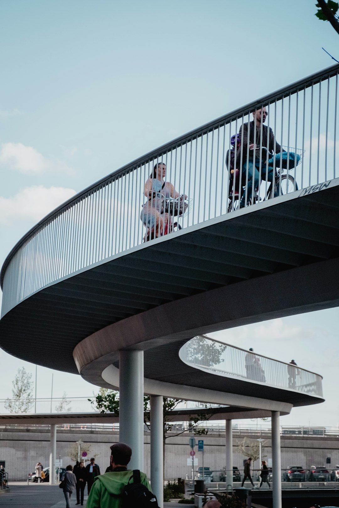 man and woman riding bicycle near bridge during daytime