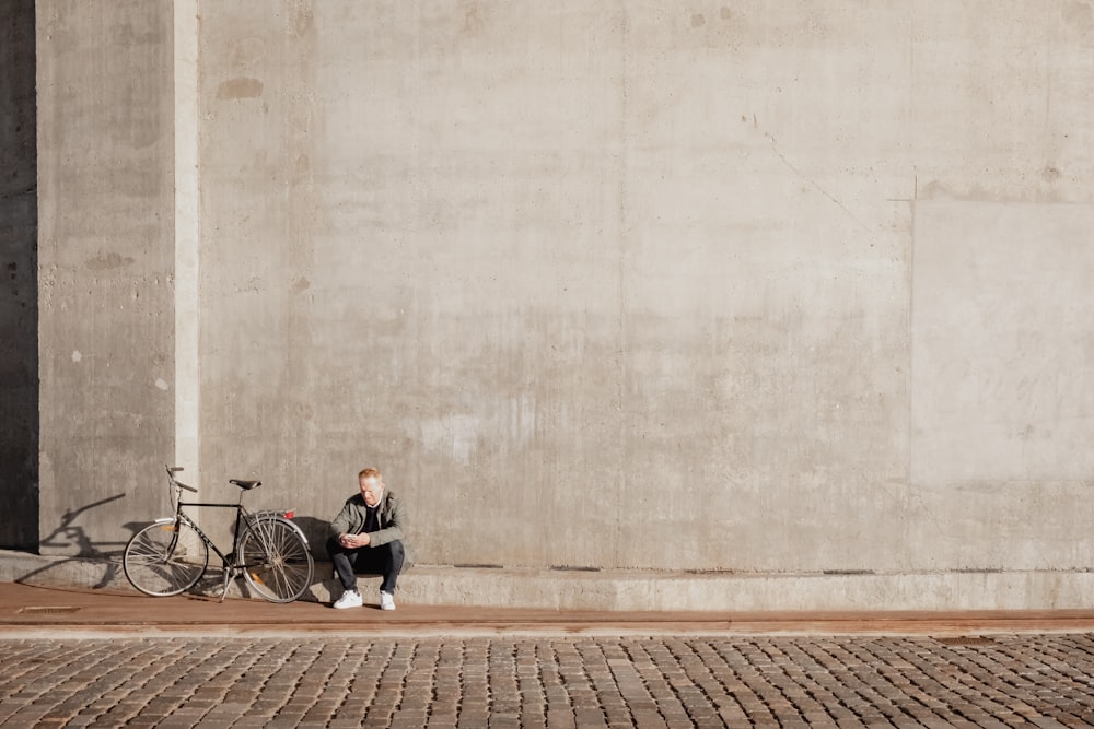 a person sitting on a bench next to a bike