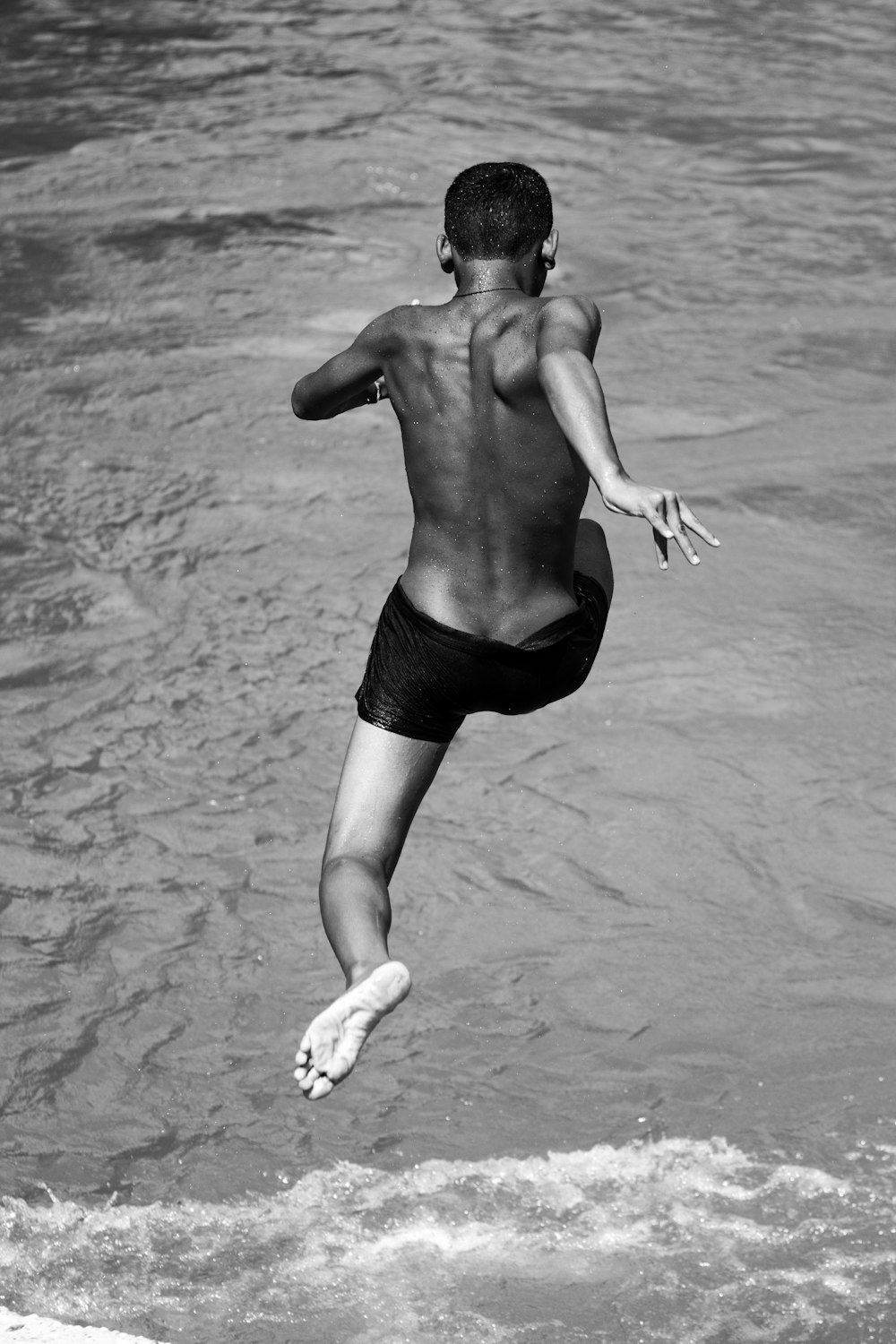 topless man jumps on to water