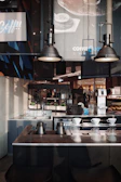 A sleek office breakroom with a modern coffee station and minimalist black and gold accents.