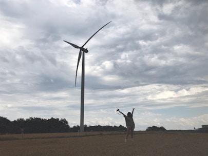 Close-up of a handshake between a landowner and a turbine company representative near a turbine site.