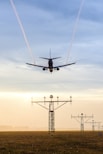 plane over electric tower