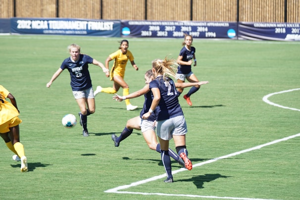 An outdoor sports activity showing students in navy blue uniforms playing soccer.