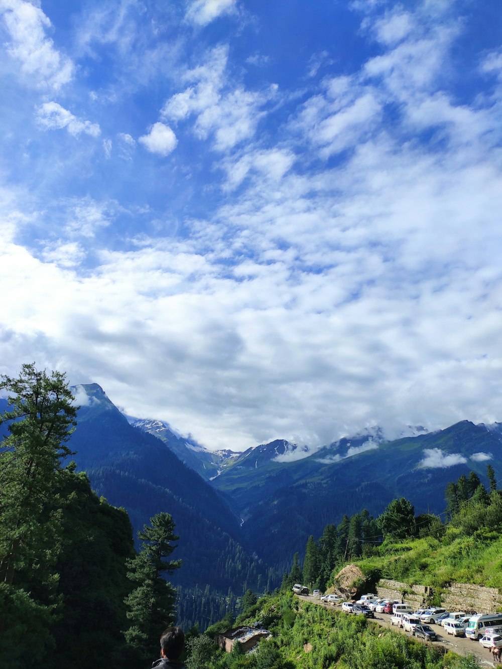 a person standing on a hill looking at the mountains