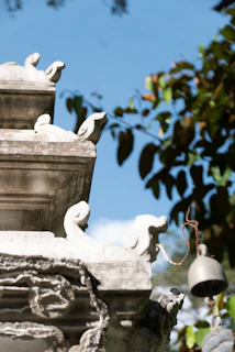 Close-up of a weathered temple bell with intricate carvings, softly glowing in the afternoon sun.