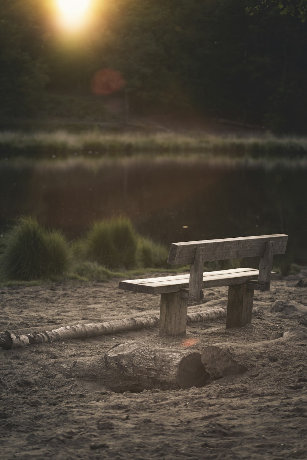 graue Holzbank vor ruhigem Wasser