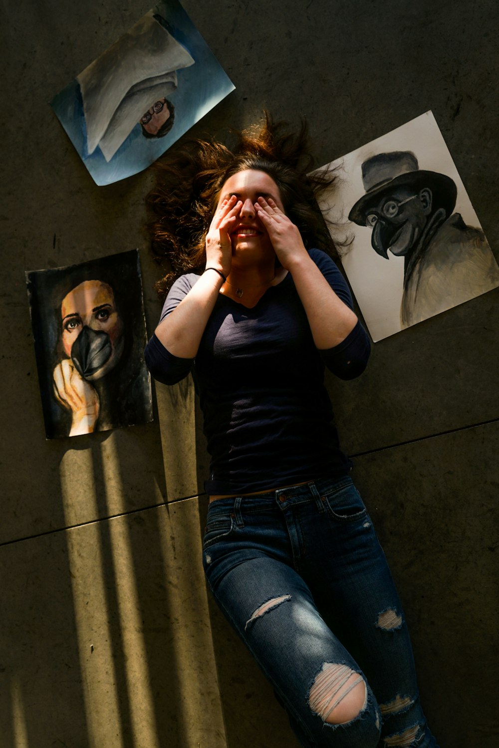 woman lying wearing black shirt and distressed blue denim jeans