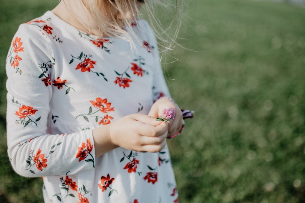 girl holds pink flower