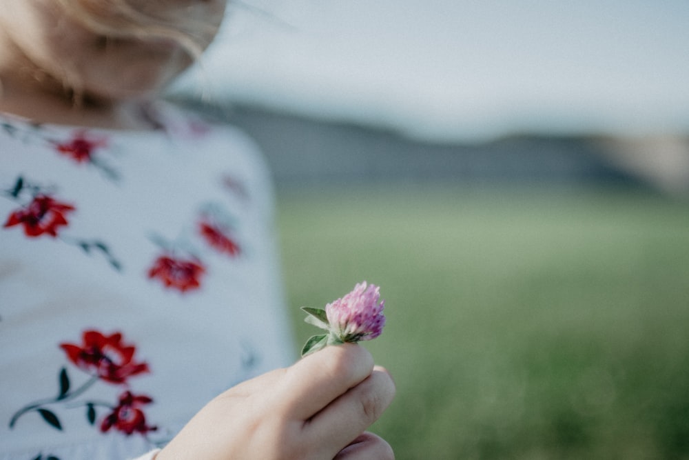 close view of girl holds pink flower