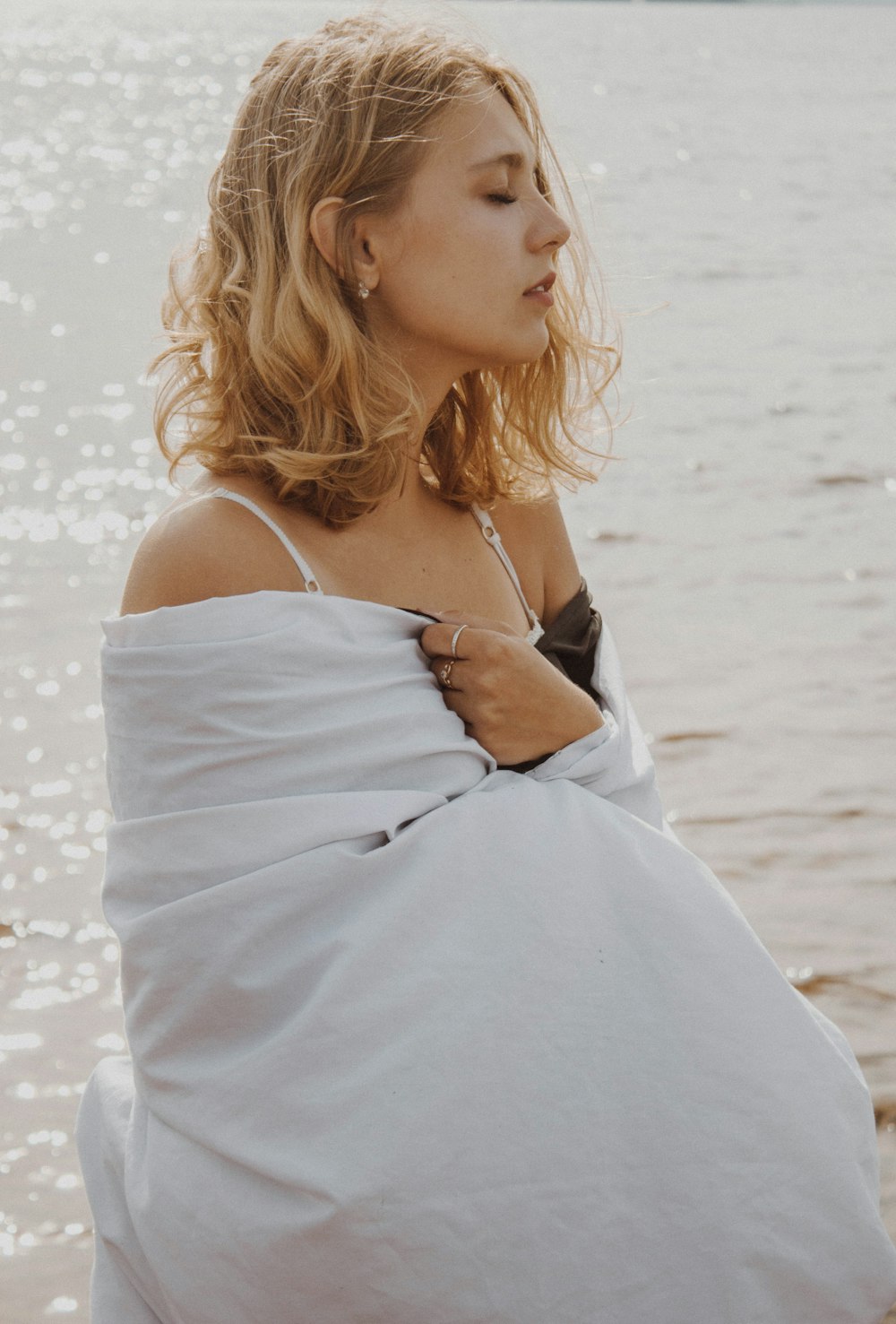 woman closing eyes standing near sea