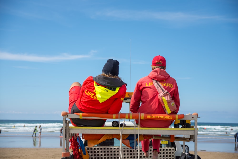 two lifeguards watching the people at the beach during daytime