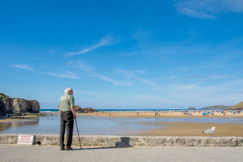 El hombre se para y mira la vista de la marea baja de la playa