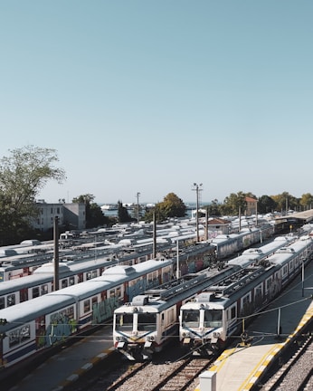 A busy freight yard with trucks lined up, ready for dispatch under a clear blue sky.