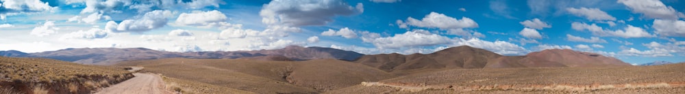 a panoramic view of mountains and clouds in the sky