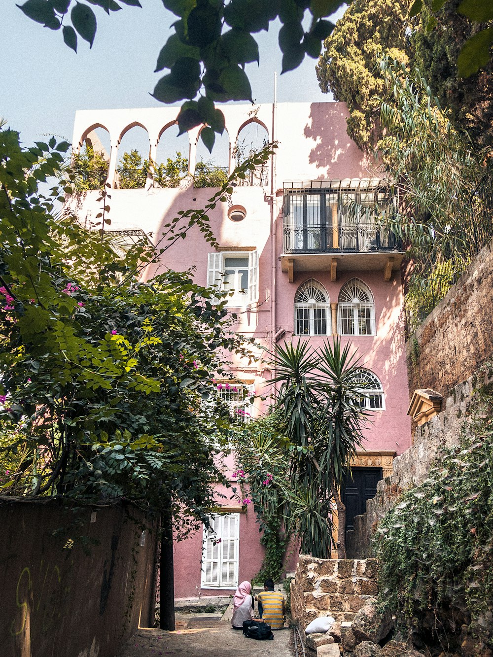 green trees near pink building