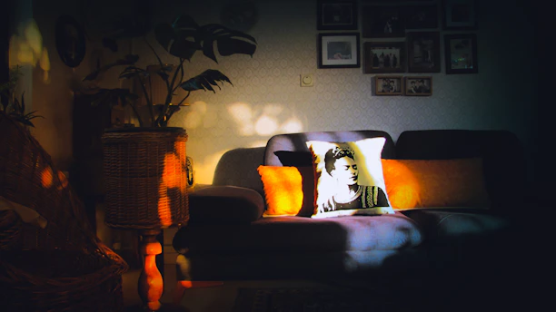A cozy living room corner with cushions printed in delicate nouveau art motifs, bathed in natural light.
