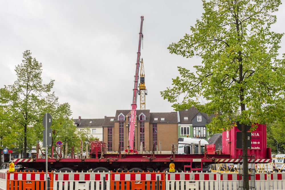 crane beside building and trees during daytime