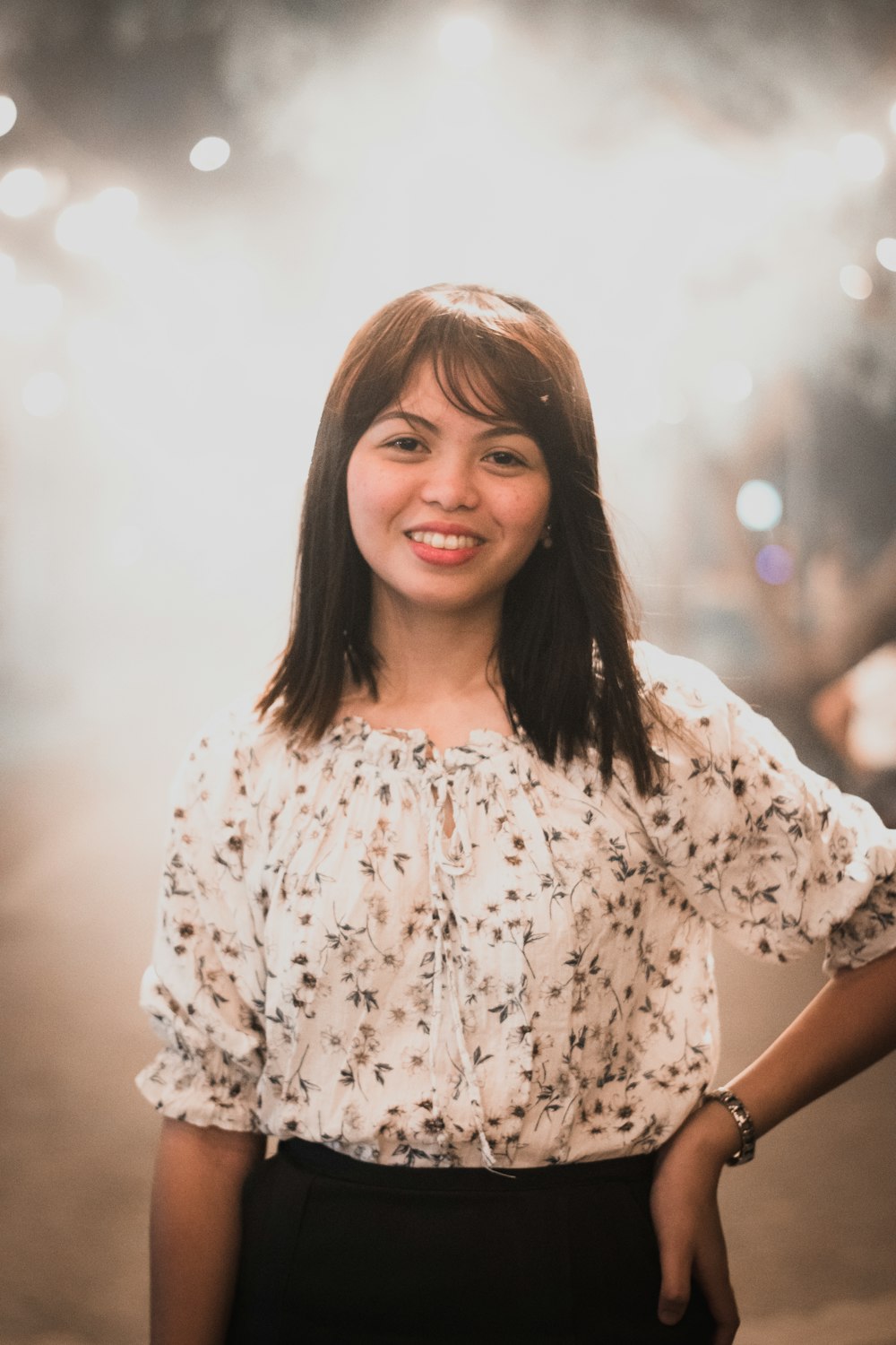 woman wears white floral blouse