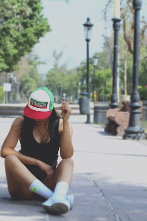 A person wearing a brimhouse cap outdoors, with a casual urban background.