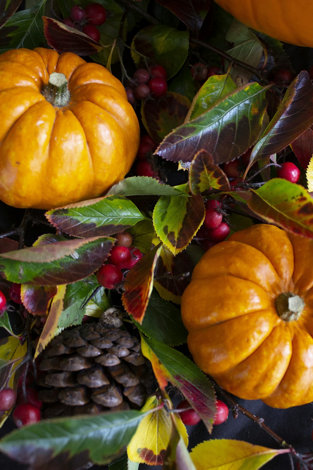 a table topped with lots of pumpkins and leaves