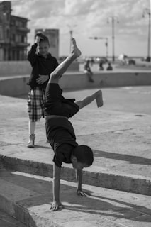 A joyful moment as a child lands a handstand, with teammates clapping in the background.