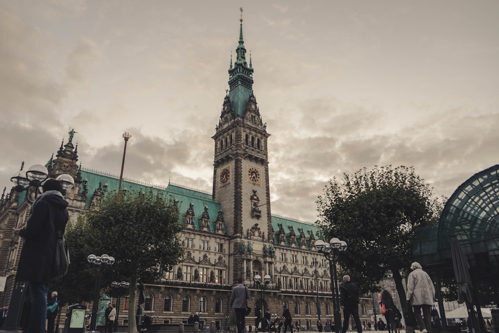people walking near Hamburg City Hall in Germany under gray skies during daytime