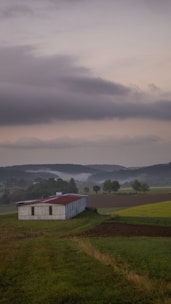 A tranquil farm landscape with fields and a rustic barn.