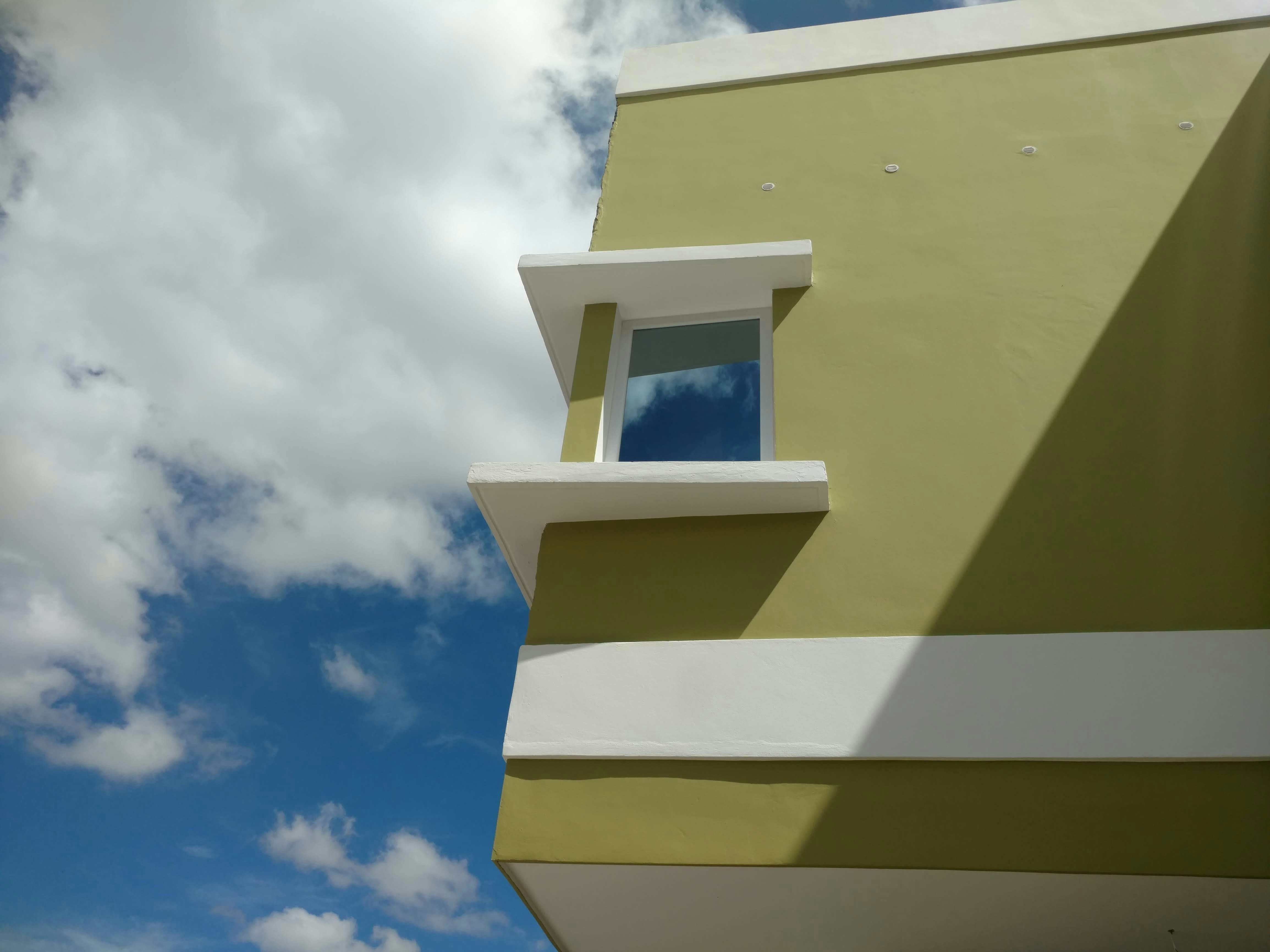 a yellow and white building with a blue sky in the background