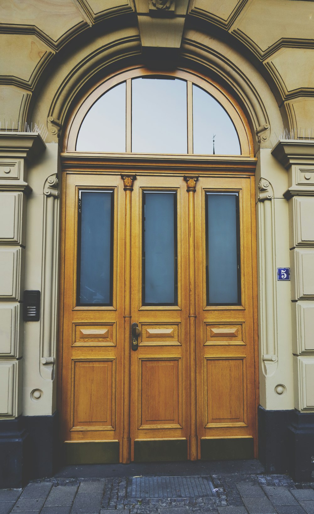 une paire de portes en bois sont ouvertes sur un bâtiment
