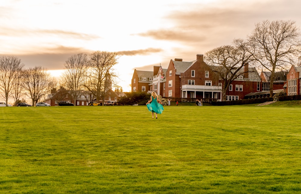 a woman in a blue dress is flying a kite