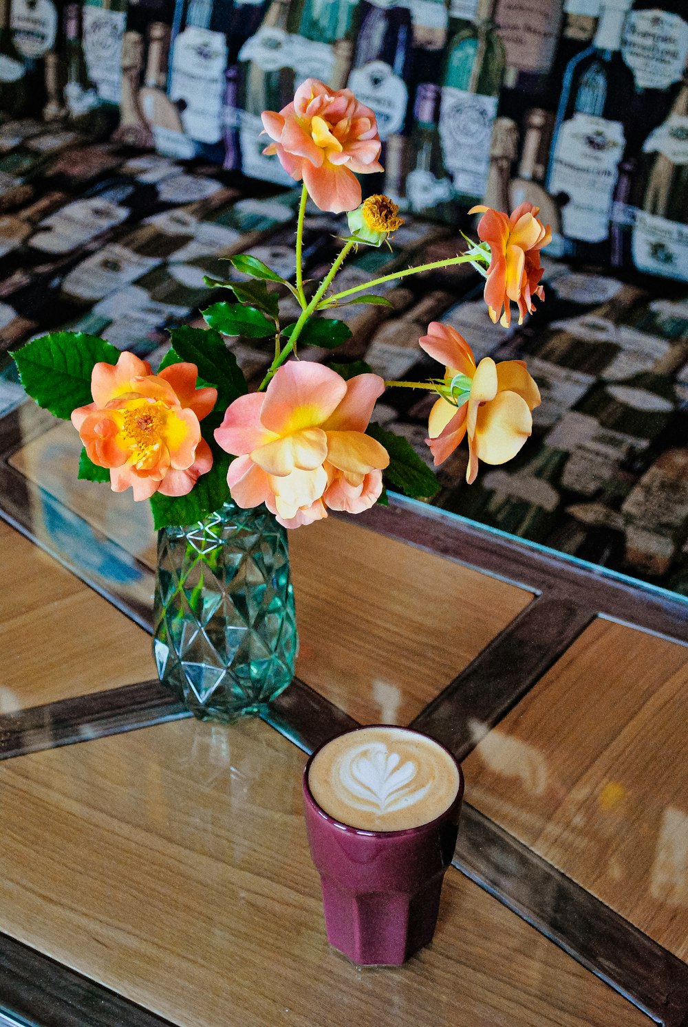 green-leafed plant with orange flowers in green glass vase