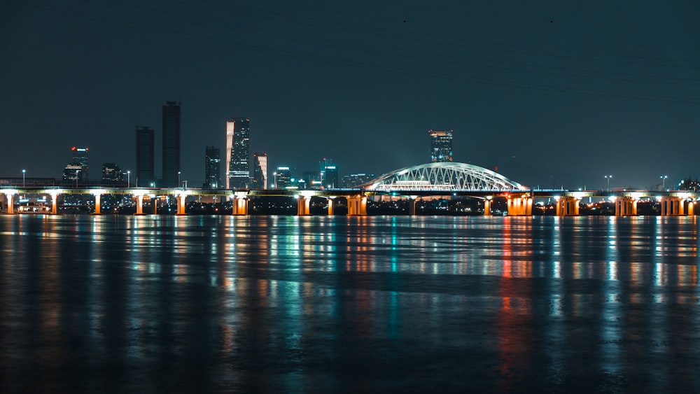 calm water front of lighted buildings at night