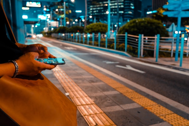 A person using a smartphone in a city setting.