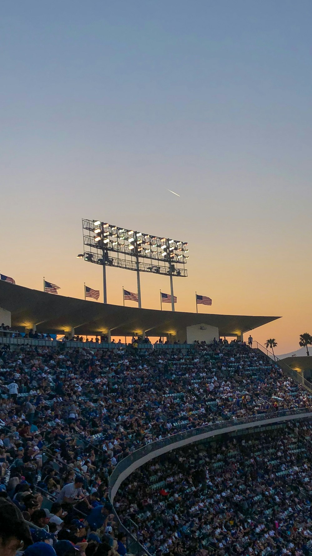 people sitting on stadium chairs during golden hour