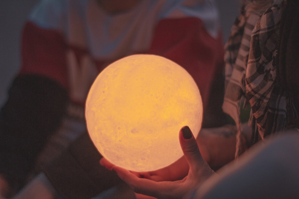 person holds lighted ball