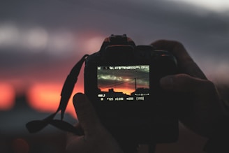 A close-up of a camera lens capturing a vibrant urban scene at sunset.