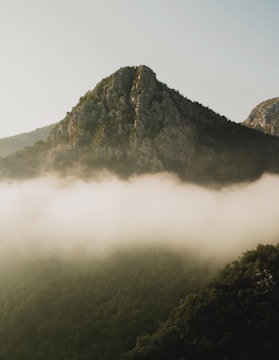 A misty peak rising above Tahitian valleys under soft morning light