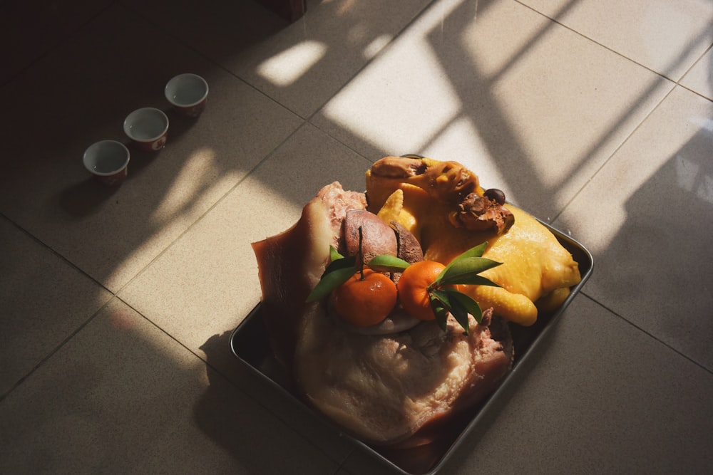 raw meat with orange fruits on tray