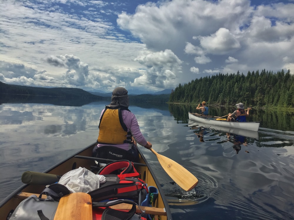 men on boats on body of water