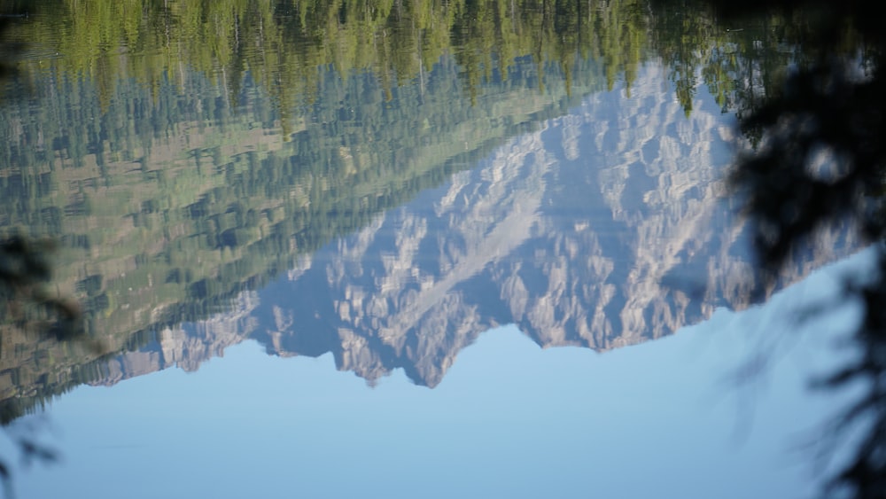 macro photography of body of water reflecting mountain during daytime