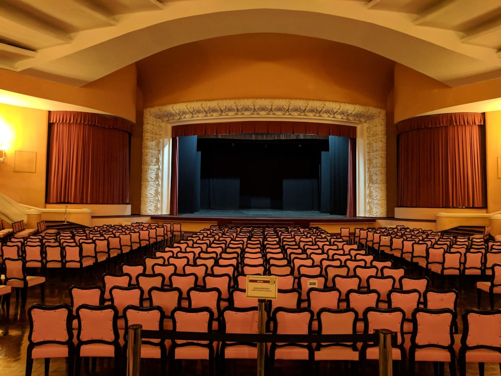 white-and-black chairs near stage inside building