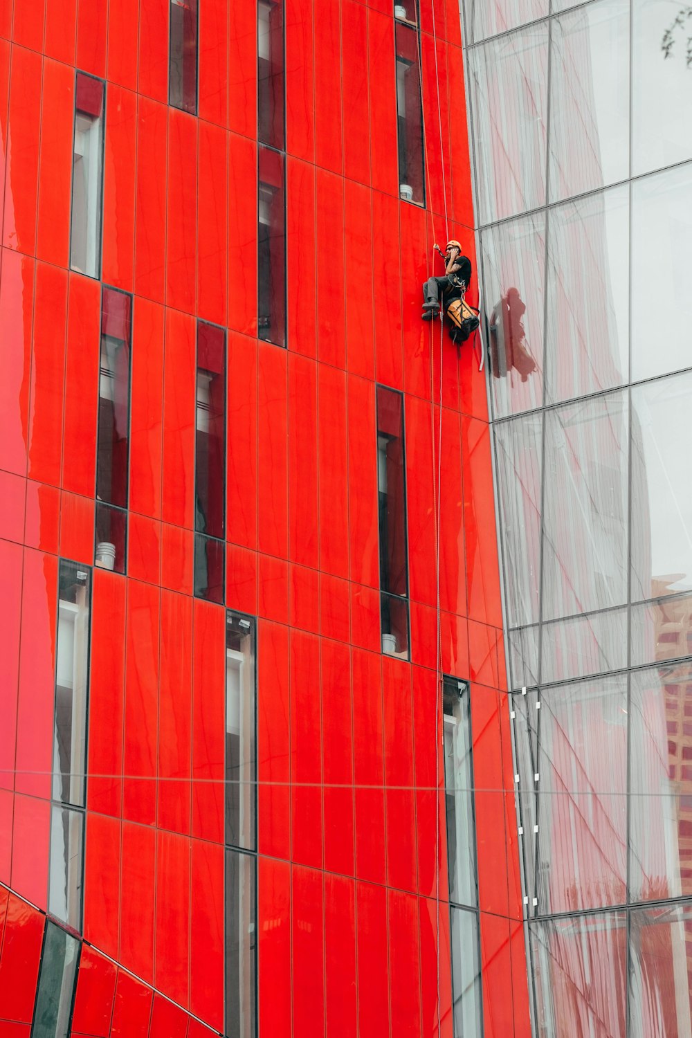 man climbing on red building